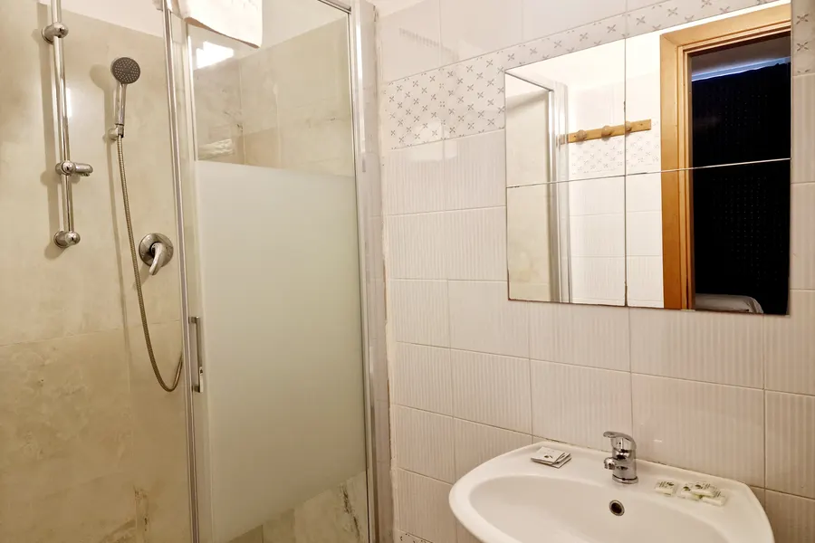 Bagno privato con doccia e piastrelle bianche