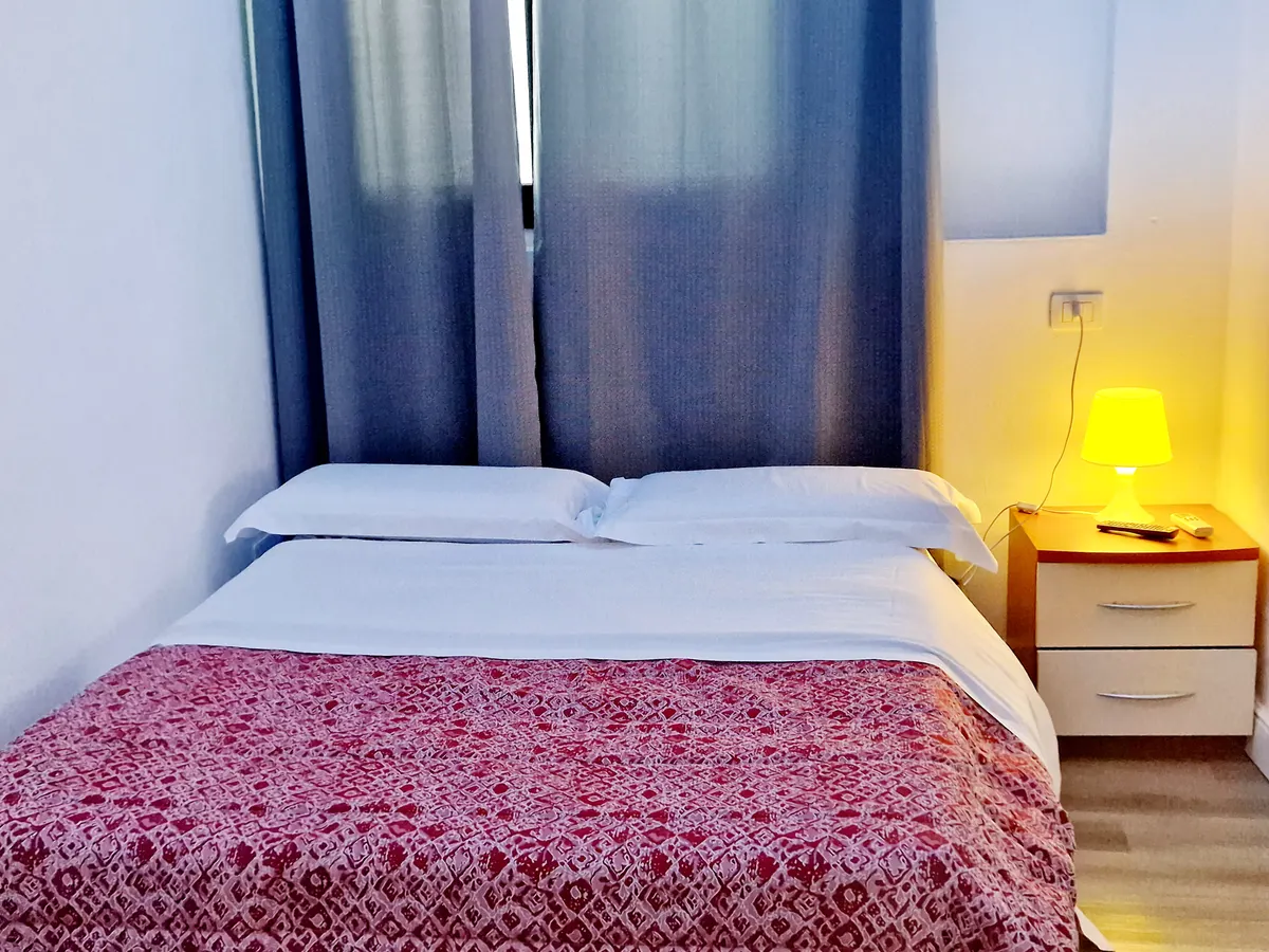 Camera doppia con letto matrimoniale e lampade da comodino